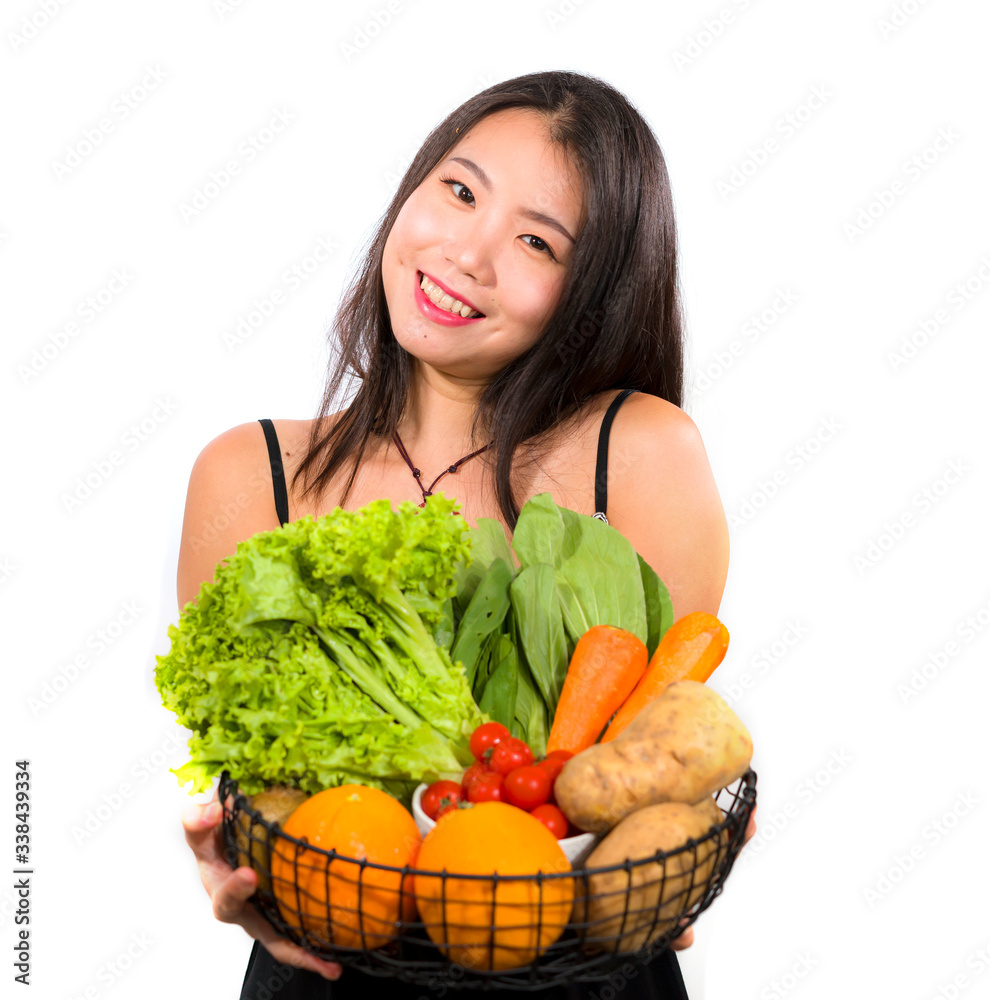 young happy and beautiful Asian Chinese woman holding basket full of fresh vegetables and fruits smiling cheerful in healthy organic and natural nutrition young happy and beautiful Asian Chinese woman holding basket full of fresh vegetables and fruits smiling cheerful in healthy organic and natural nutrition