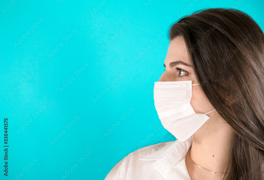 Horizontal shot of beautiful dark haired woman wearing medical disposable mask Horizontal shot of beautiful dark haired woman wearing medical disposable mask