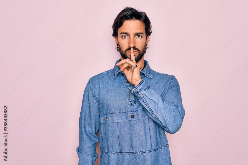 Young handsome hispanic bohemian man wearing hippie style over pink background asking to be quiet with finger on lips. Silence and secret concept. Young handsome hispanic bohemian man wearing hippie style over pink background asking to be quiet with finger on lips. Silence and secret concept.
