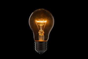 Old, dirty light bulb close up on black background