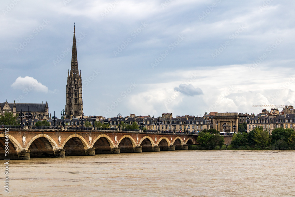Pont de pierre et clocher de la basilique Saint-Michel depuis la Garonne (Bordeaux, France)