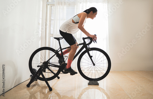 Asian woman cyclist. She is exercising in the house.By cycling on the trainer