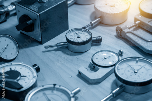 The group of dial indicator gauge on the table with lighting effect. The group of measurement instrument for  industrial purpose in the light blue scene.