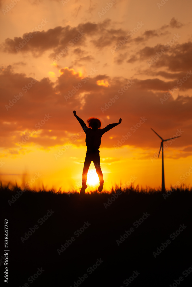 Silhouette of happy children jumping playing at sunset time