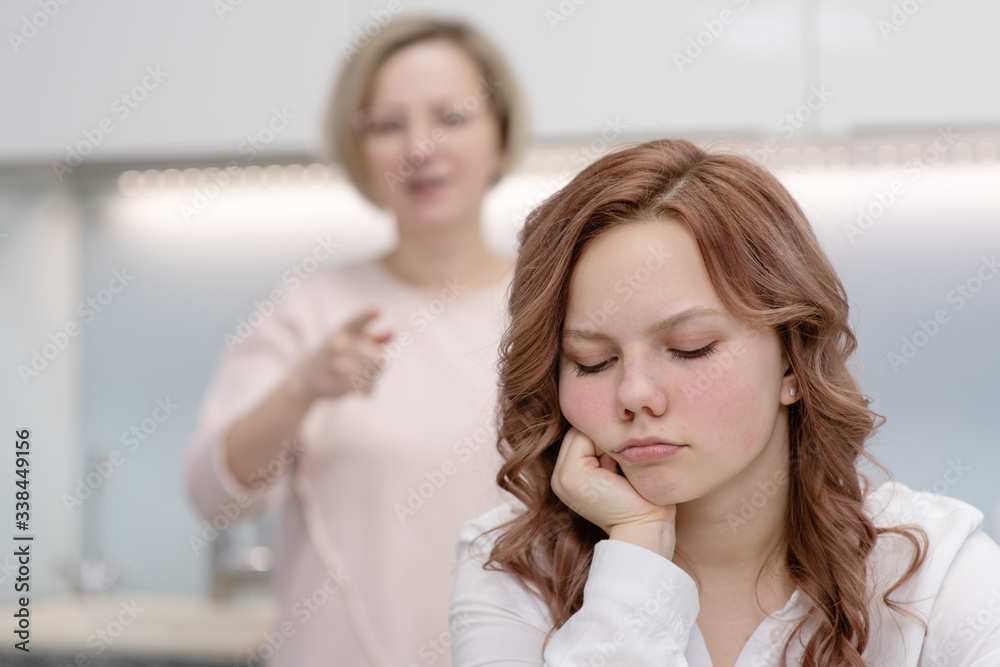 Mom scolds the daughter of a teenager while she ignores the mother. Relationship problem concep Mom scolds the daughter of a teenager while she ignores the mother. Relationship problem concep