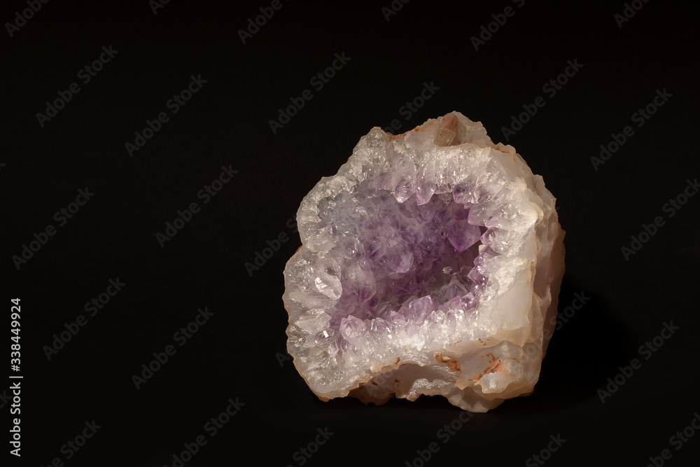 Untreated mineral amethyst quartz is a soft lilac color, isolated on a black background. Semiprecious stone. House decoration Untreated mineral amethyst quartz is a soft lilac color, isolated on a black background. Semiprecious stone. House decoration