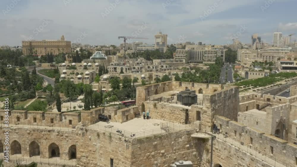 JERUSALEM, ISRAEL - MAY 18, 2016: View to the city new part and King David Hotel over the Tower of David western wall located near the Jaffa Gate entrance of the Old City. JERUSALEM, ISRAEL - MAY 18, 2016: View to the city new part and King David Hotel over the Tower of David western wall located near the Jaffa Gate entrance of the Old City.