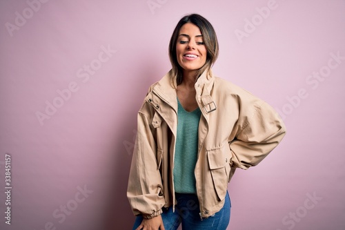 Young beautiful woman wearing fashion urban clothes, model wearing casual street style standing over pink background © Krakenimages.com