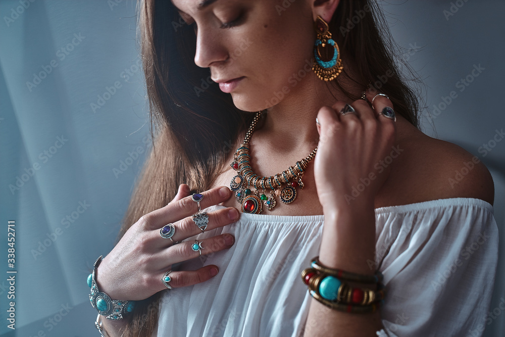 Vogue boho chic woman wears white blouse with gold necklace, big earrings,  bracelets with stone and silver rings. Fashionable indian hippie gypsy  bohemian outfit with jewelry details Stock Photo | Adobe Stock