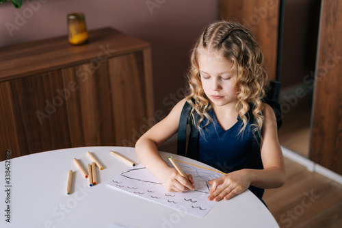 Adorable happy little girl drawing with pencils at home. Concept of child creative activity.