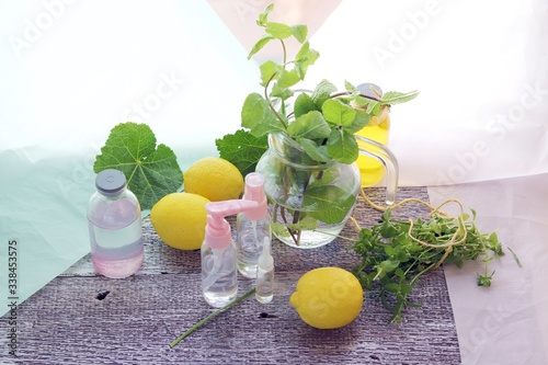 Hand disinfectant gel, mint leaves, fresh lemons, vegetable oils on a wooden table, the concept of a healthy lifestyle, home body care products