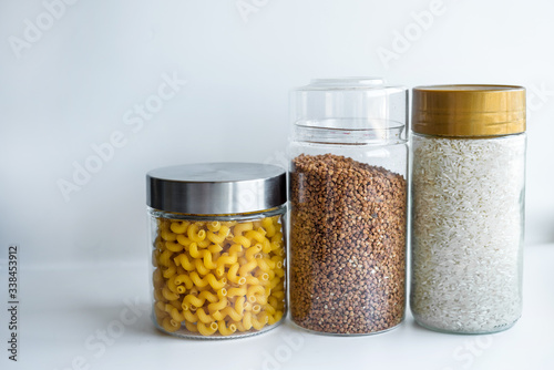 pasta and cereals in glass jars on a white background