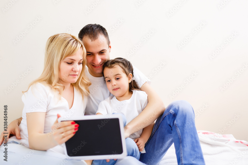 Family lying on a carpet with tablet in the living room Family lying on a carpet with tablet in the living room