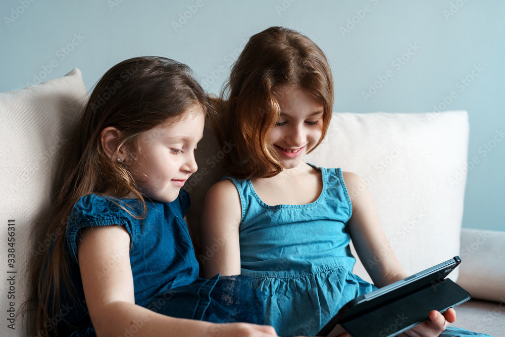 Children use the tablet for self-education during quarantine. Girls study online. Children are looking for information on the Internet. Children use the tablet for self-education during quarantine. Girls study online. Children are looking for information on the Internet.