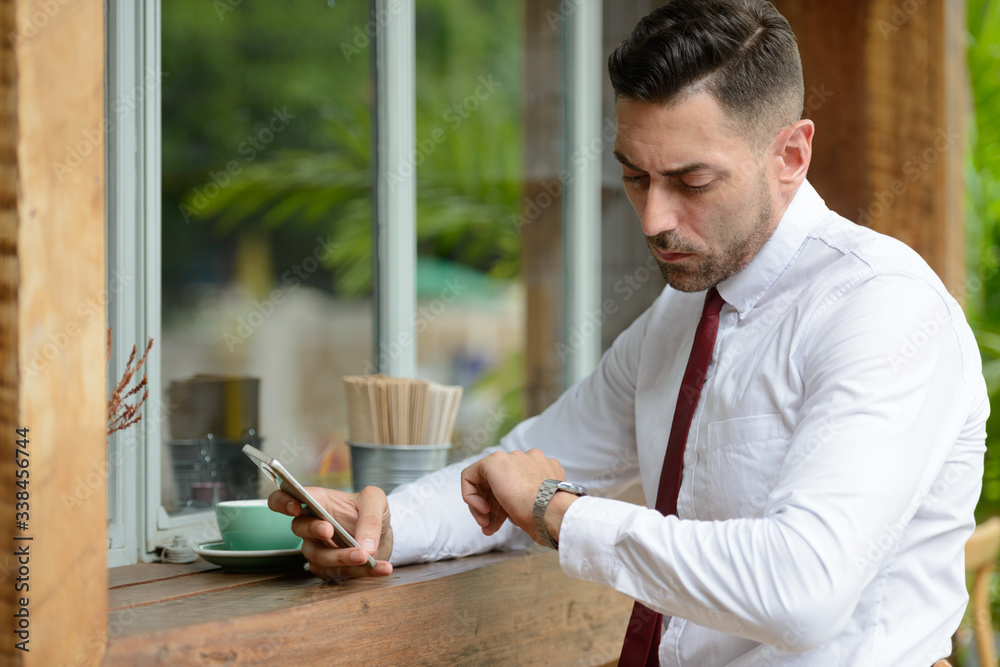 Portrait of businessman waiting and checking time at the coffee shop Portrait of businessman waiting and checking time at the coffee shop