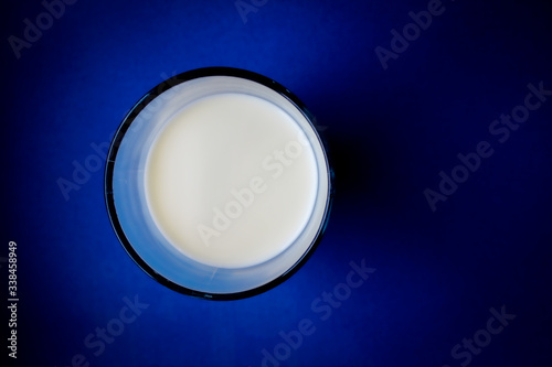 Glass of milk top view on with blue background