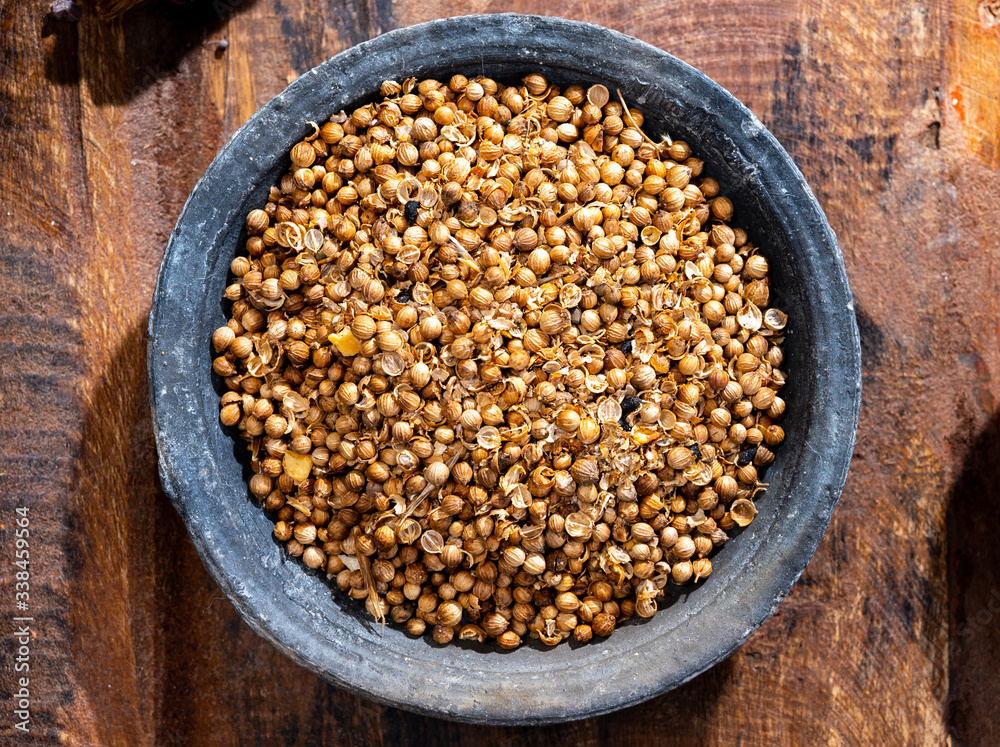 Indian spices collection, dried coriander seeds in clay bowl top view Indian spices collection, dried coriander seeds in clay bowl top view