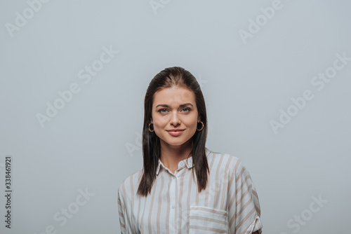 Attractive woman smiling at camera isolated on grey