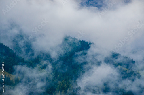 Mountain landscape, high mountains of the alpine ridge. Forest in the highlands. Forest, sky and solitude with nature. Alpine landscape. Alps of Switzerland. Alps of Italy. Mountain valleys surrounded