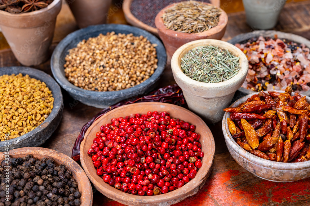 Indian spices collection, dried colorful condiment, nuts, pods and seeds and another spices in clay bowls Indian spices collection, dried colorful condiment, nuts, pods and seeds and another spices in clay bowls