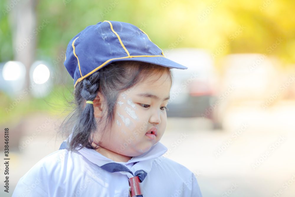 Portrait of Asian little girl student in uniform at outside buildings