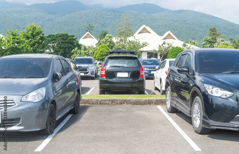 Car parked in asphalt parking lot and one empty space parking in nature with trees and mountain background. Car parked in asphalt parking lot and one empty space parking in nature with trees and mountain background.