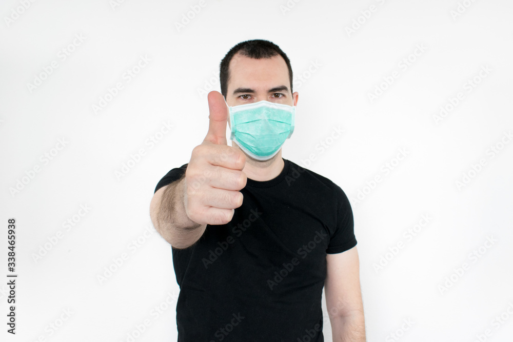 caucasian male man young. standat white background, wear mask on face, thumbs up gesture one hand, protect yourself, safe people. Coronavirus. caucasian male man young. standat white background, wear mask on face, thumbs up gesture one hand, protect yourself, safe people. Coronavirus.