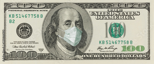 A 100-dollar bill with a face mask by Benjamin Franklin from the COVID-19 Coronavirus in the United States. photo