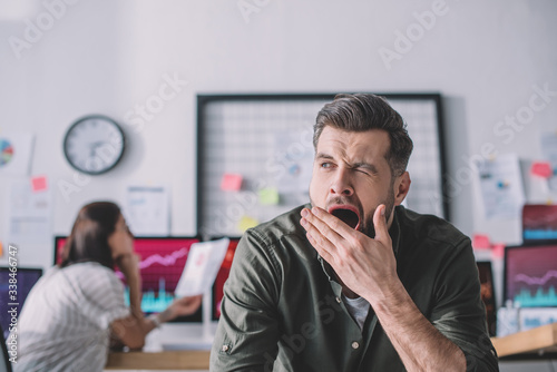Selective focus of data analyst yawning in office photo