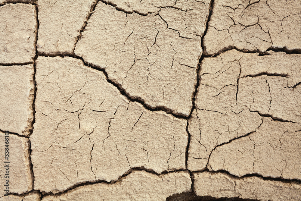 Fototapeta premium Cracks in the earth in rural areas. Ground texture background. Dry soil abstract photo. Mosaic pattern