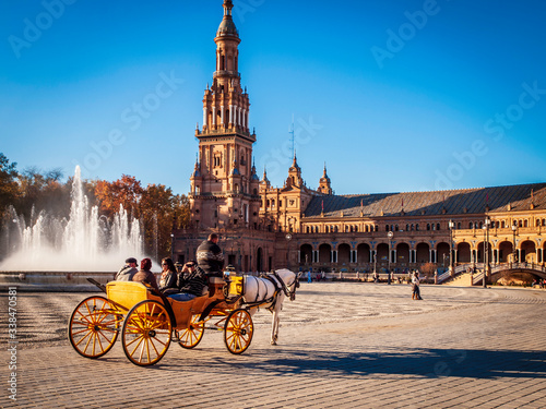 Típico coche de caballos con turistas en la plaza de España de Sevilla