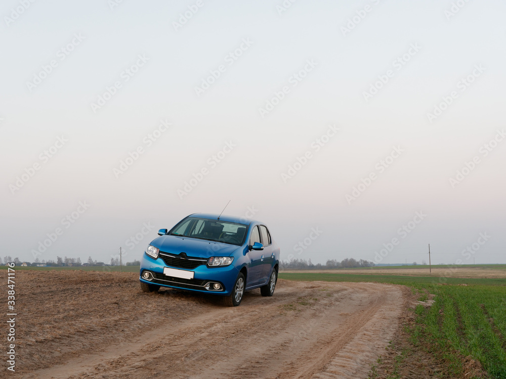 Belarus blue car in a field in spring at sunrise Belarus blue car in a field in spring at sunrise