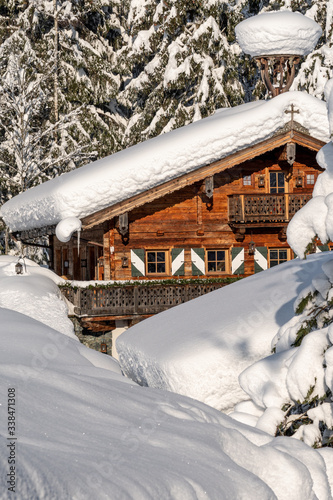 verschneites Bauernhaus in Tirol in der Morgensonne
