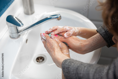 Mother washing hands her son carefully with soap and sanitizer  close up. Prevention of pneumonia virus spreading  protection against coronavirus pandemia. Hygiene  sanitary  cleanliness  disinfection