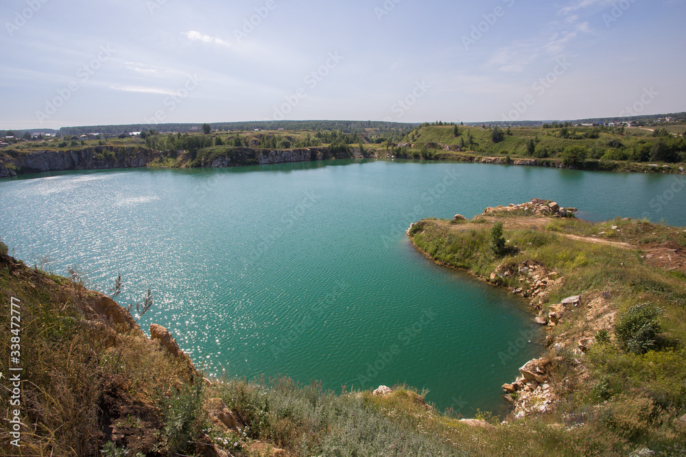 Flooded open pit quarry with blue water lake