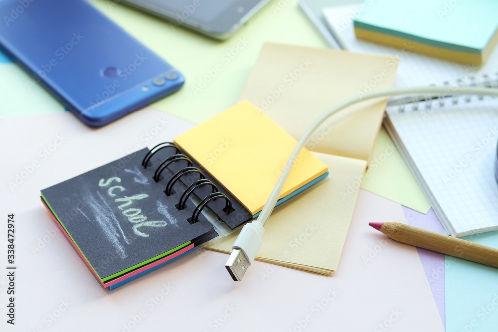 Fototapeta premium School stationery, tablet, phone on the desk, home schooling concept, part interior children's room, back to school