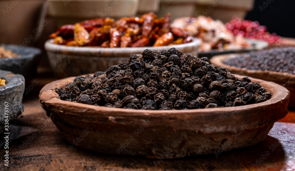 Indian spices collection, dried black peppercorns and another spices in clay bowls Indian spices collection, dried black peppercorns and another spices in clay bowls