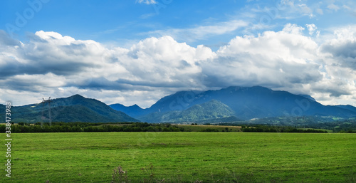Romanian typical natural landscape in country of Suceava: green fields and mountains on horizon, Romania.
