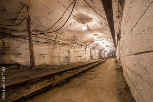 Underground gold mine shaft tunnel drift with rails and light