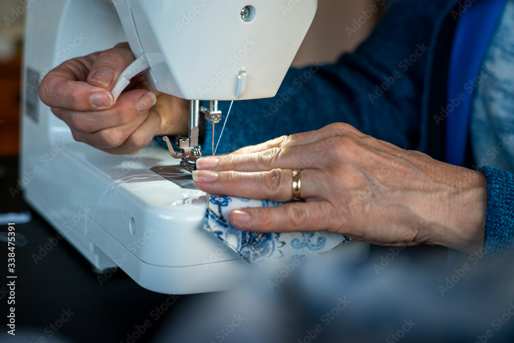 A woman sews an article of clothing on her sewing machine.