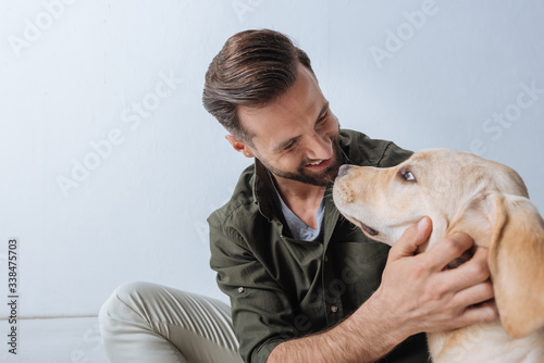 Wallpaper Mural Handsome man smiling at golden retriever on white background Torontodigital.ca