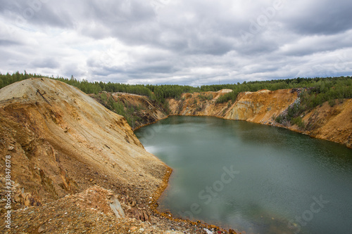 Flooded copper pyrite open pit quarry with green water lake