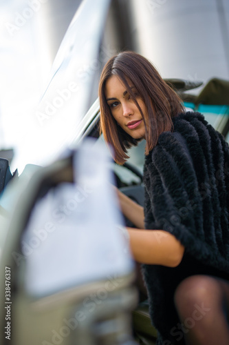 beautiful girl looks as she opens a car door