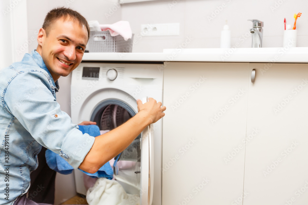 Man loading cloths to washing machine. View from inside the washing machine. Man loading cloths to washing machine. View from inside the washing machine.