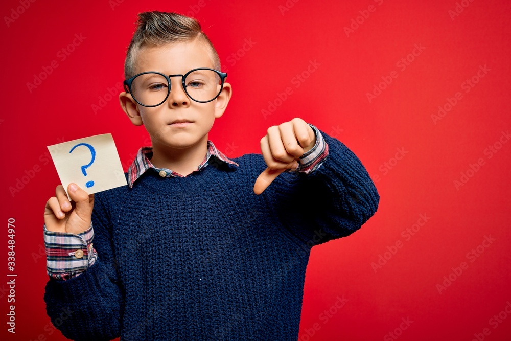 Young little caucasian kid wearing glasses holding paper note with ...