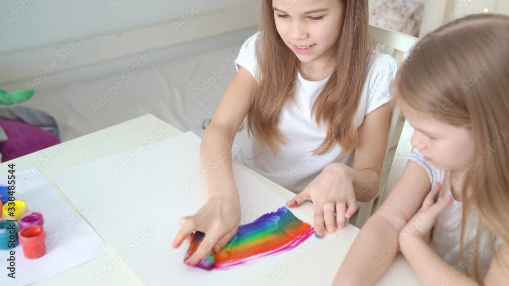 two sisters drawing rainbow. stay at home. two sisters drawing rainbow. stay at home.