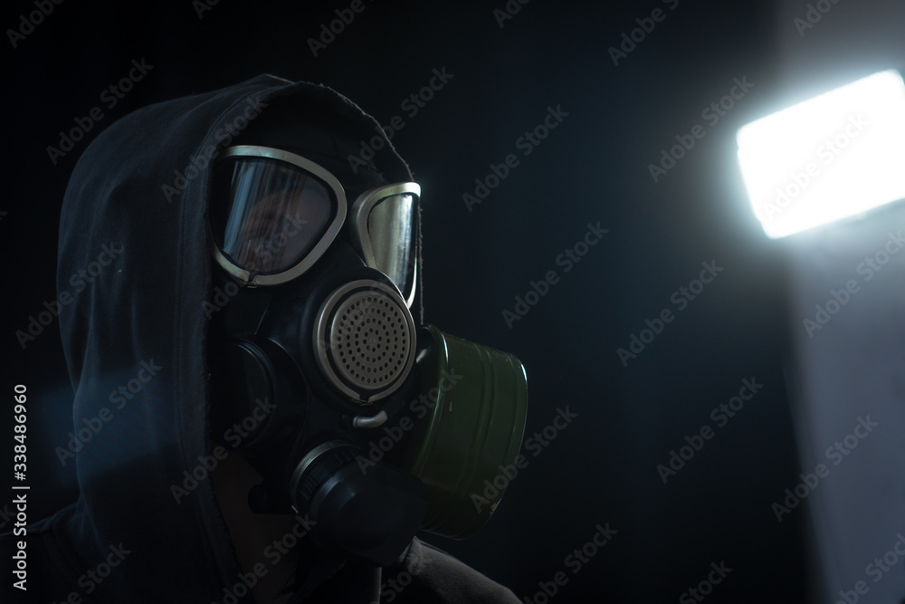 The girl is wearing a military gas mask. Isolated on a black background. Respiratory protection against harmful toxic substances, aerosols and viruses. Copy space, place for text. The girl is wearing a military gas mask. Isolated on a black background. Respiratory protection against harmful toxic substances, aerosols and viruses. Copy space, place for text.