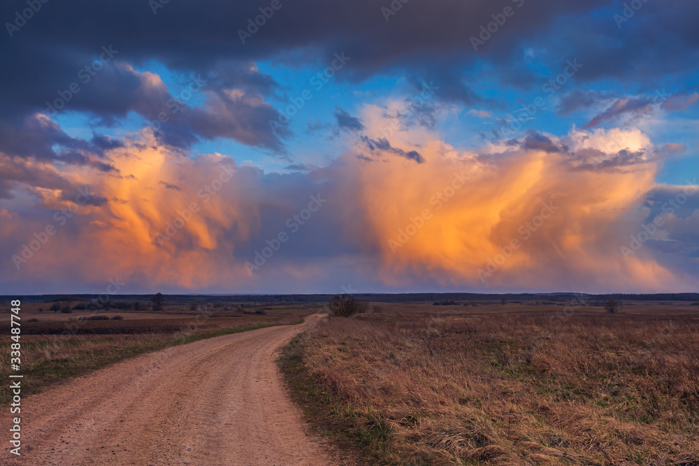 Path to cumulonimbus red storm clouds at sunset, beautiful landscape