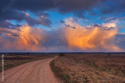 Path to cumulonimbus red storm clouds at sunset  beautiful landscape
