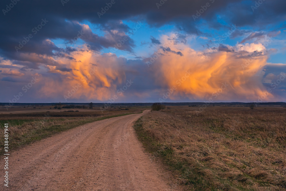 Path to cumulonimbus red storm clouds at sunset, beautiful landscape